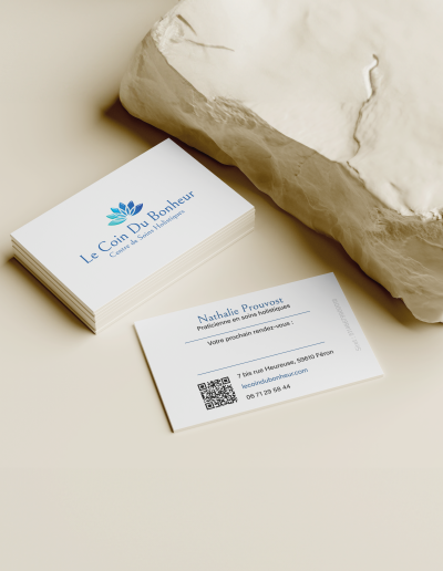Carte de visite blanche avec logo bleu, design épuré pour le Coin du Bonheur, centre de soins holistiques.